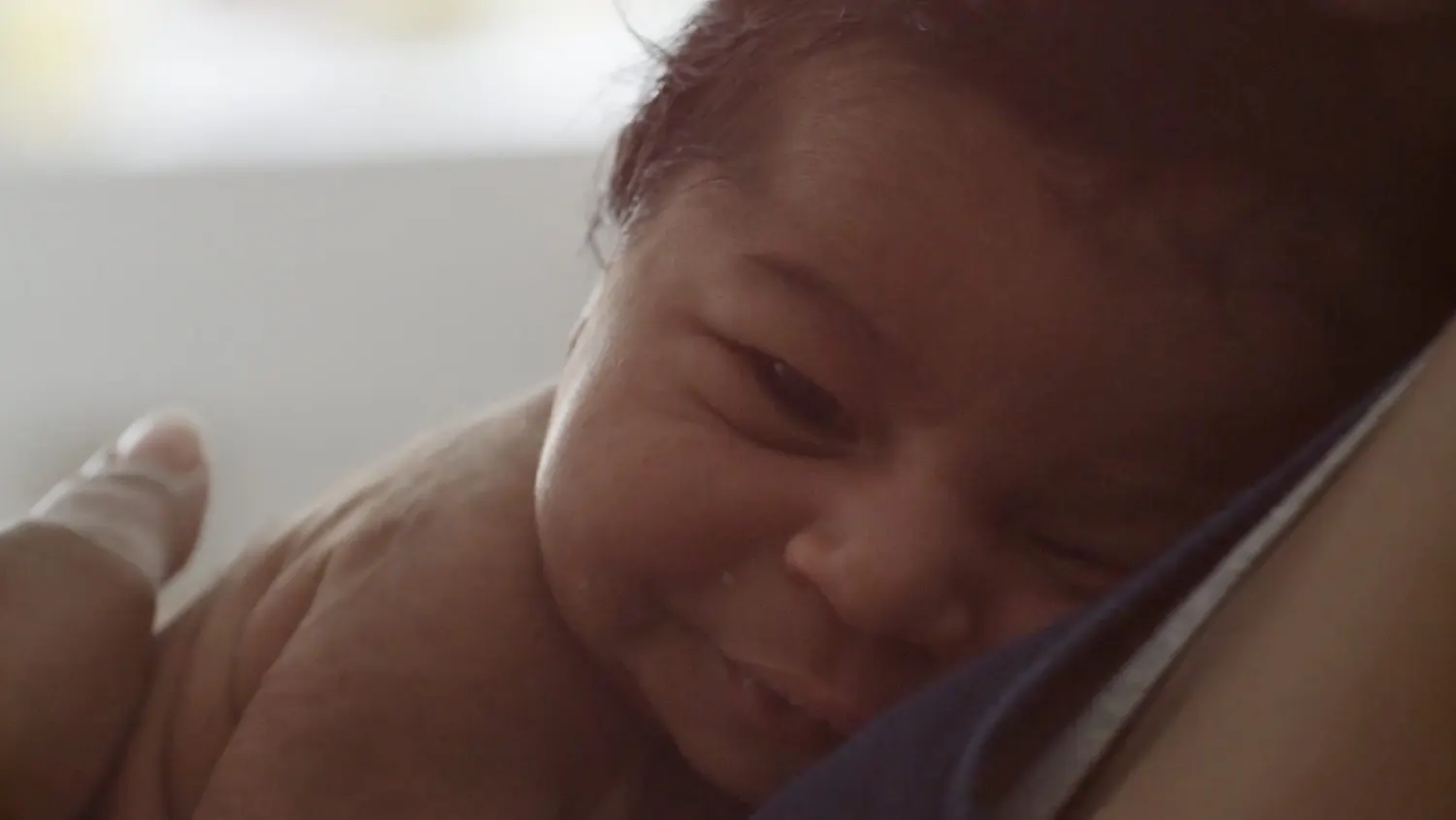 Newborn baby smiling, from Libero's The Welcome Project